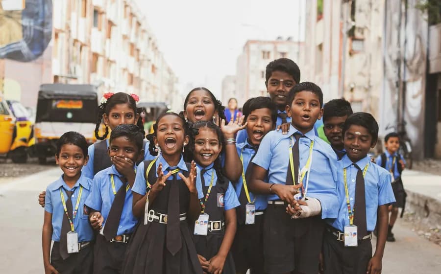 A group of primary-school children in uniform, wearing their ID cards on lanyards